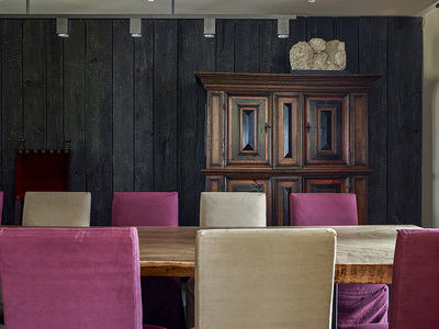 Salle à manger avec table en bois massif avec mur en bardage de bois brûlé